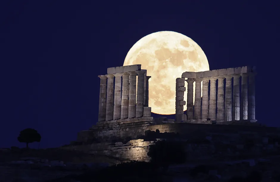 CAPE SOINIO, GREECE - JUNE 24: Full moon, also known as the Strawberry Moon, rises behind Temple of Poseidon, near capital city Athens, in Cape Sounio, Greece on June 24, 2021. (Photo by Ayhan Mehmet/Anadolu Agency via Getty Images)