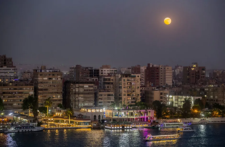 TOPSHOT - The full Strawberry moon, the last super moon of the year, rises above the Egyptian capital Cairo, on June 24, 2021. (Photo by Khaled DESOUKI / AFP) (Photo by KHALED DESOUKI/AFP via Getty Images)