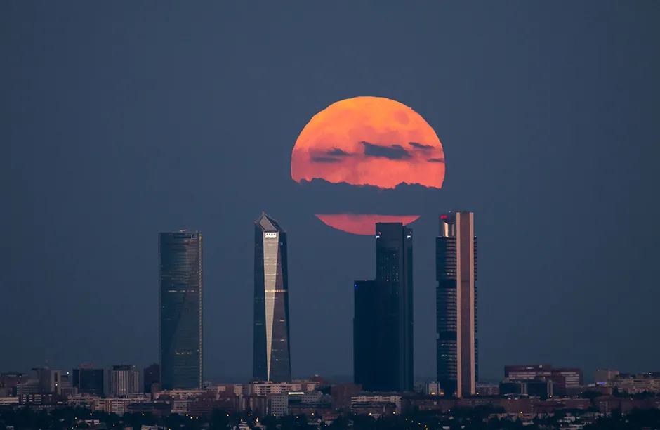 MADRID, SPAIN - 2021/06/24: The full moon of June also known as Strawberry Moon rises over the Four Towers Business area skyscrapers in downtown Madrid. (Photo by Marcos del Mazo/LightRocket via Getty Images)