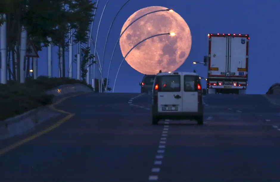 ANKARA, TURKEY - JUNE 25: The Full Moon, known as the Strawberry Moon, is seen as vehicles are on their way on a highway at early morning in Ankara, Turkey on June 25, 2021. (Photo by Ismail Duru/Anadolu Agency via Getty Images)