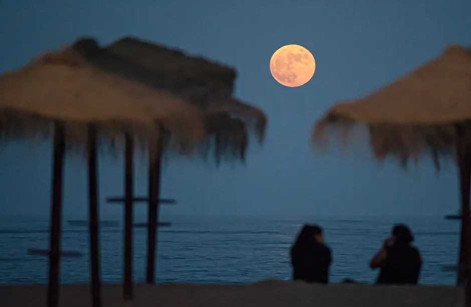 MALAGA, SPAIN - 2021/06/24: The full super moon rising over Malagueta beach. According to NASA, the 'strawberry moon' is the last super moon of the year 2021. Its name has origin from Native Americans, who picked strawberries during the harvest. (Photo by Jesus Merida/SOPA Images/LightRocket via Getty Images)