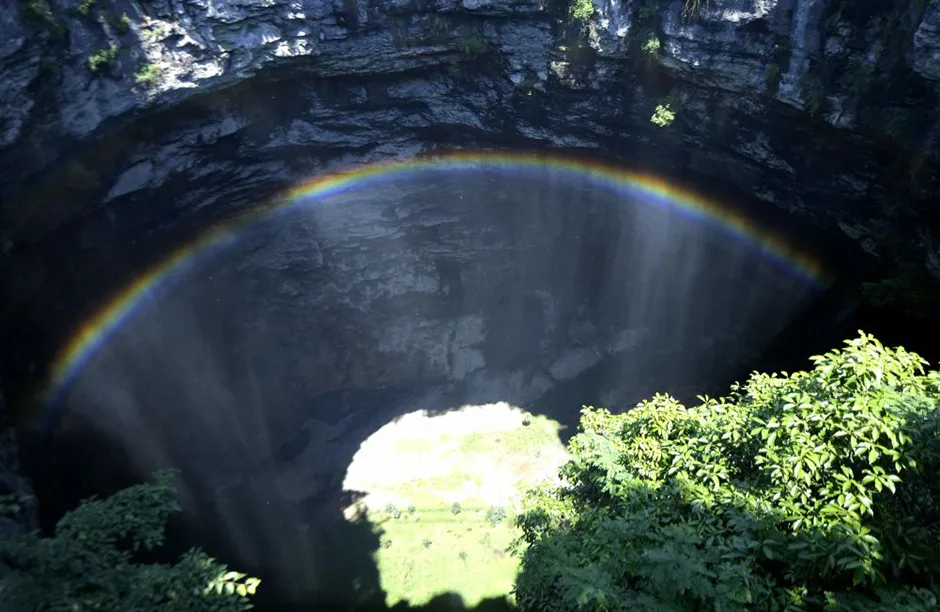 XUAN EN, CHINA - JUNE 23: A rainbow is seen at a 290-meter deep karst sinkhole, located near the village of Luoquanyan, on June 23, 2021 in Xuan en County, Enshi Tujia and Miao Autonomous Prefecture, Hubei Province of China. (Photo by Song Wen/VCG via Getty Images)