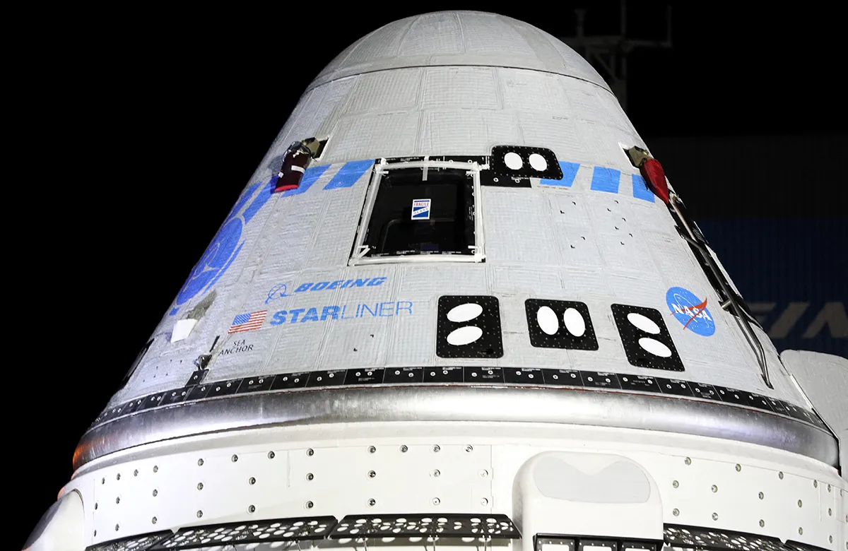 A detailed view of the CST-100 Starliner spacecraft shows one of the glass windows with a protective covering outside their Commercial Cargo and Processing Facility in the pre-dawn hours at the Kennedy Space Center in Cape Canaveral, Florida, USA, on 17 July 2021, ahead of its scheduled launch on July 30. Photo by Gregg Newton/AFP/Getty Images