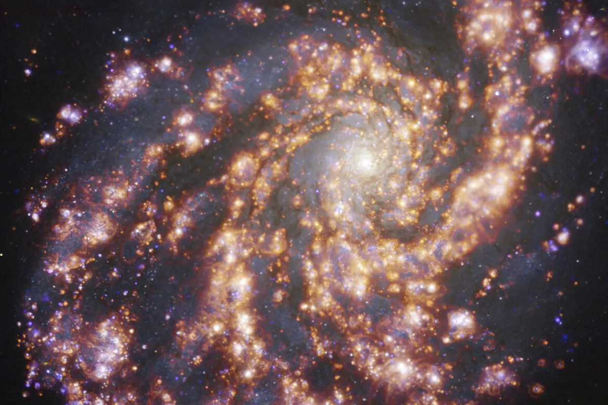 This image, taken with the Multi-Unit Spectroscopic Explorer (MUSE) on ESO’s Very Large Telescope (VLT), shows the nearby galaxy NGC 4254. NGC 4254 is a grand-design spiral galaxy located approximately 45 million light-years from Earth in the constellation Coma Berenices. The image is a combination of observations conducted at different wavelengths of light to map stellar populations and warm gas. The golden glows mainly correspond to clouds of ionised hydrogen, oxygen and sulphur gas, marking the presence of newly born stars, while the bluish regions in the background reveal the distribution of slightly older stars. The image was taken as part of the Physics at High Angular resolution in Nearby GalaxieS (PHANGS) project, which is making high-resolution observations of nearby galaxies with telescopes operating across the electromagnetic spectrum.