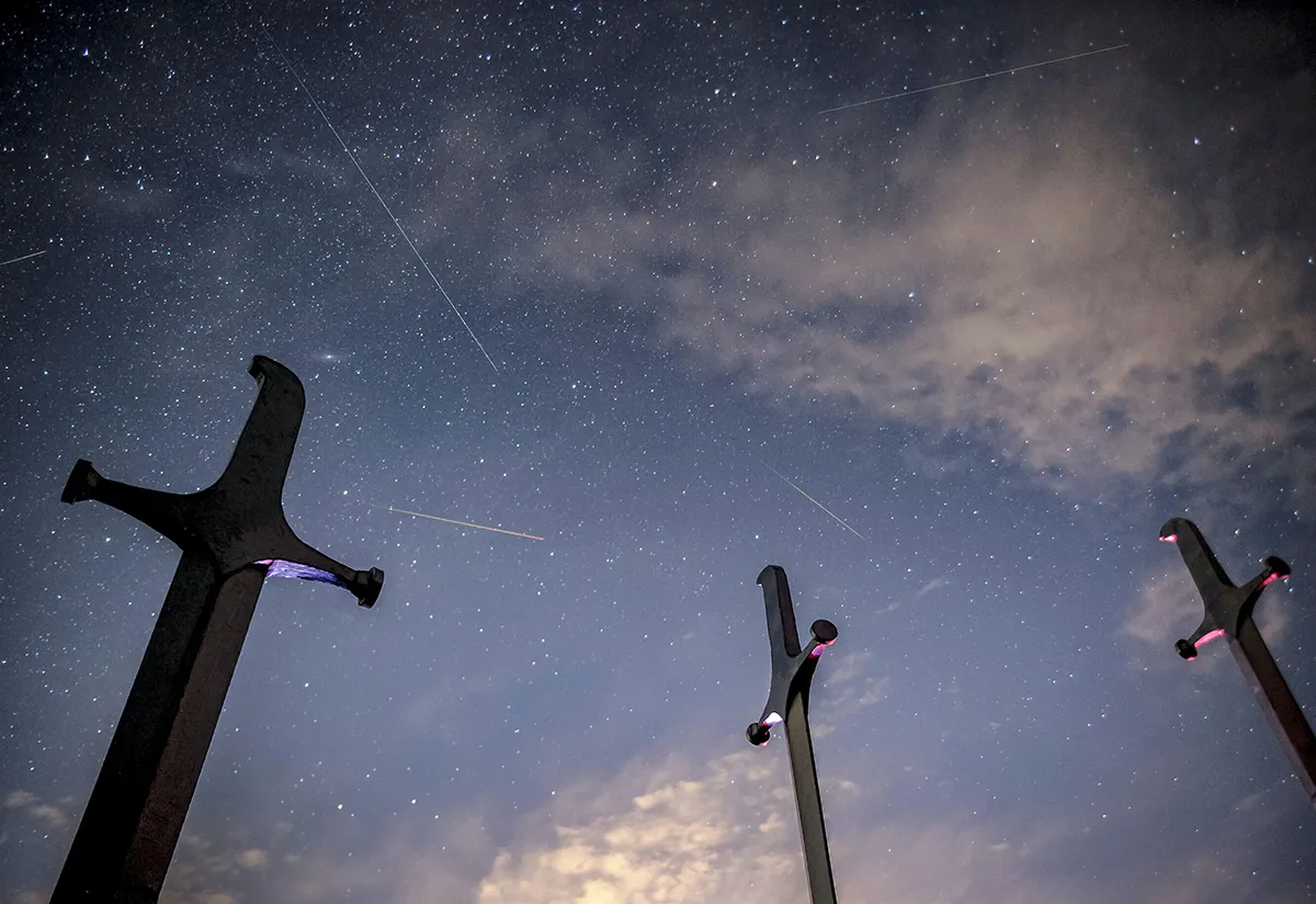 2GDG6W7 Meteors streak past stars in the night sky above the Battle of Didgori memorial complex during the annual Perseid meteor shower at Didgori, Georgia, August 13, 2021. REUTERS/Irakli Gedenidze