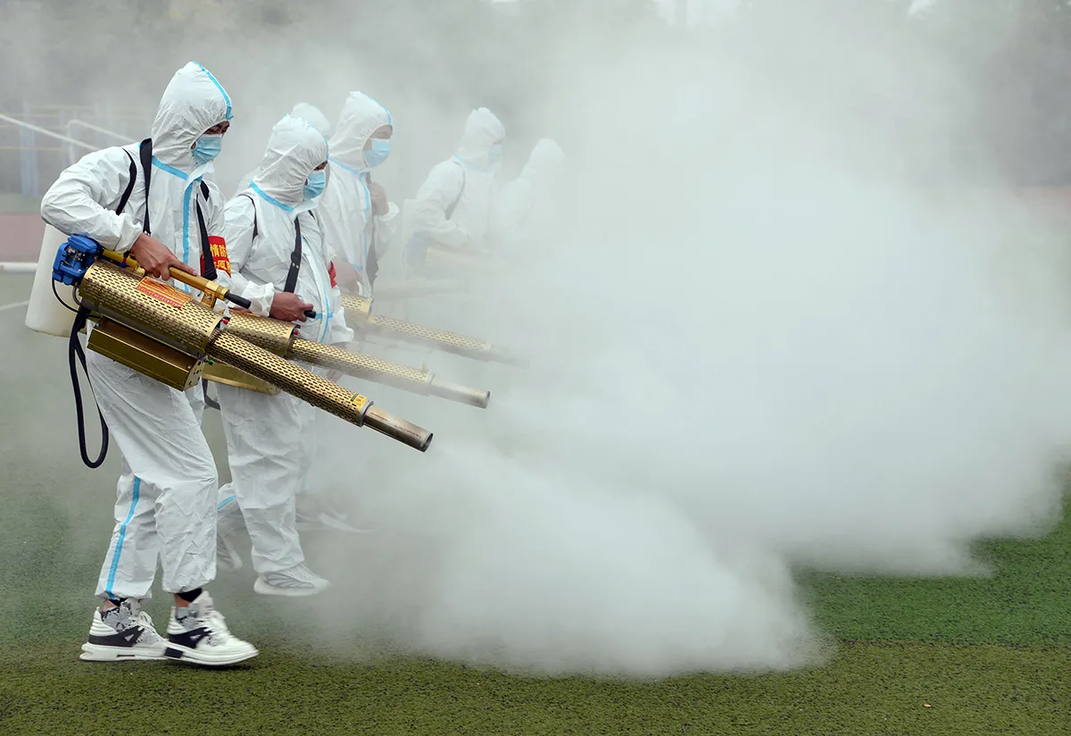 Staff members spray disinfectant at a school ahead of the new semester in Bozhou in China's eastern Anhui province on August 23, 2021. - China OUT (Photo by STR / AFP) / China OUT (Photo by STR/AFP via Getty Images)