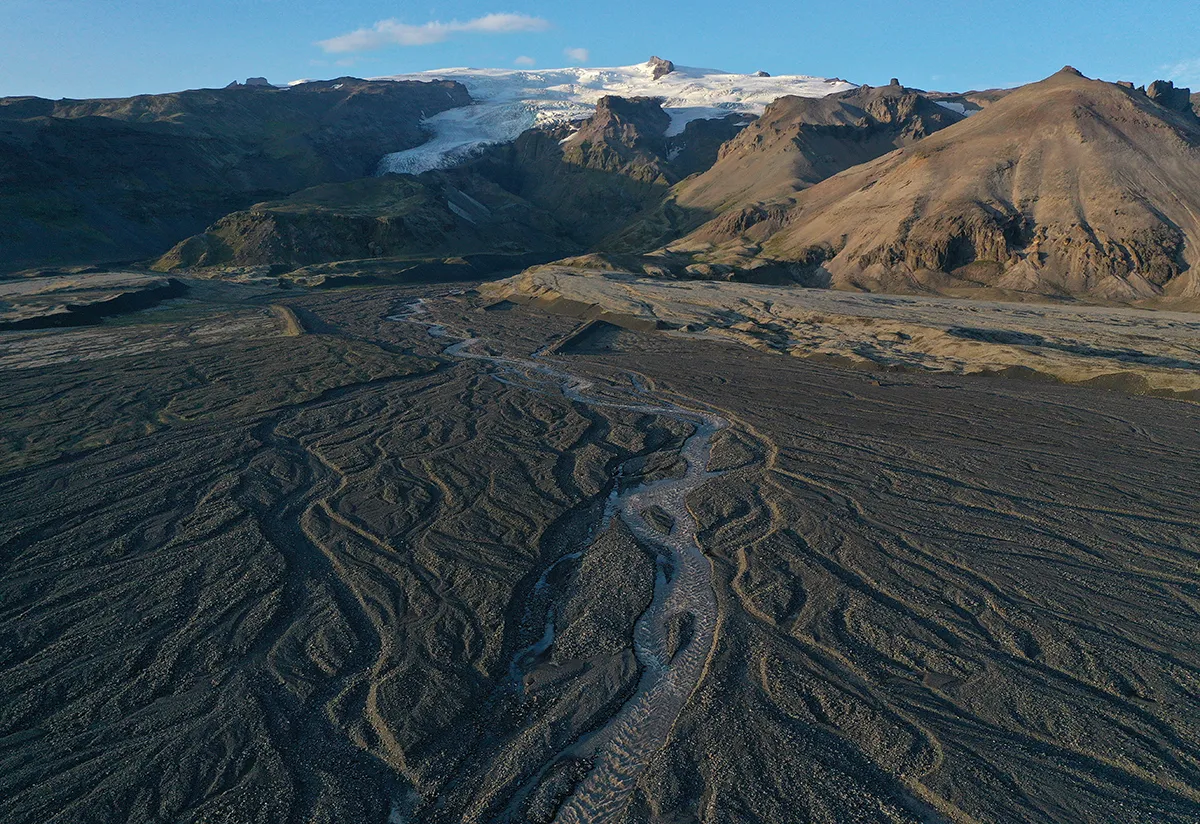 In this aerial view, meltwater descends in shifting rivulets from Vatnajokull ice cap on August 14, 2021 near Hof, Iceland. Iceland is undergoing a strong impact from global warming. Since the 1990s 90% of Iceland's glaciers have been retreating and projections for the future show a continued and strong reduction in size of its three ice caps. Fjallsjokull is one of dozens of glacier tongues that descend from Vatnajokull, Iceland's biggest ice cap, along Iceland's southeastern coast. (Photo by Sean Gallup/Getty Images)