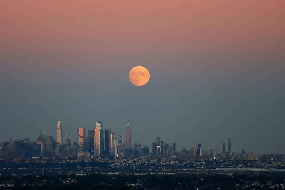 WEST ORANGE, NJ - SEPTEMBER 19: A 98.8 percent Harvest Moon rises above midtown Manhattan as the sun sets in New York City on September 19, 2021 as seen from West Orange, New Jersey. (Photo by Gary Hershorn/Getty Images)