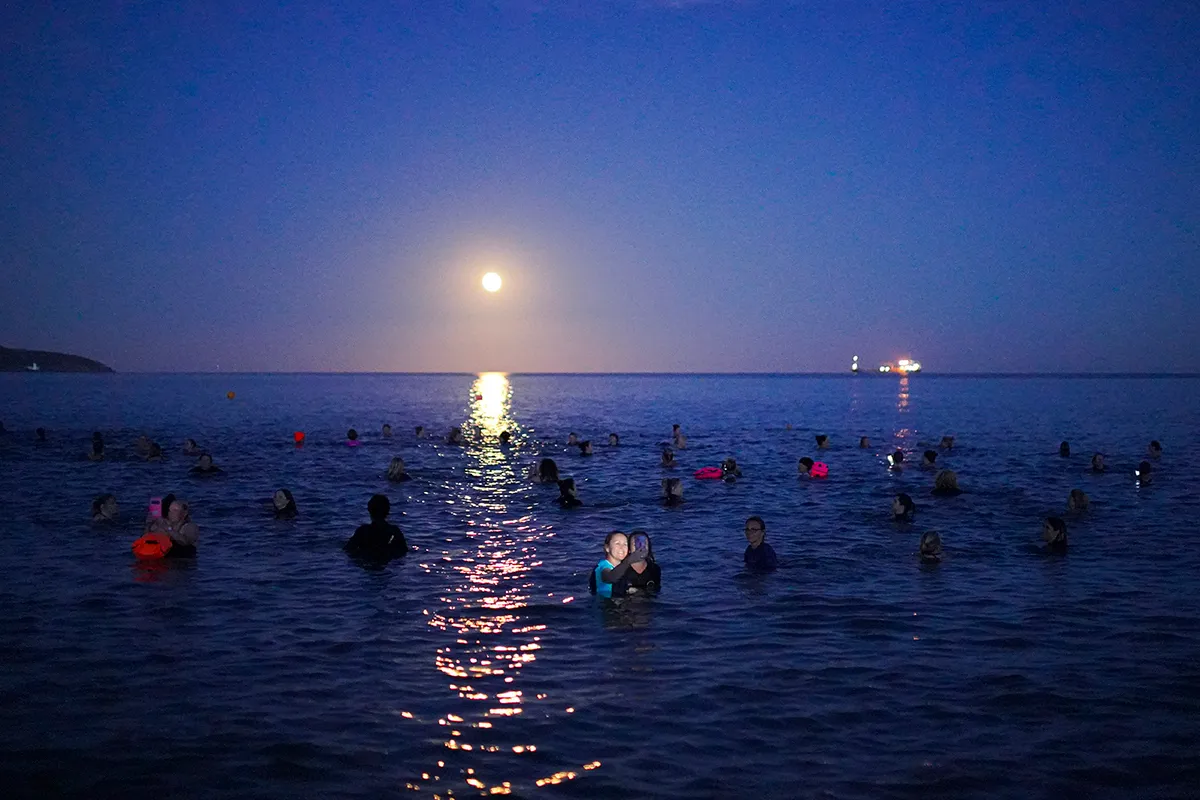 FALMOUTH, ENGLAND - SEPTEMBER 20: A group of swimmers take a selfie as they swim under the Harvest Moon on September 20, 2021 in Swanpool Beach, Falmouth, England. (Photo by Hugh R Hastings/Getty Images)