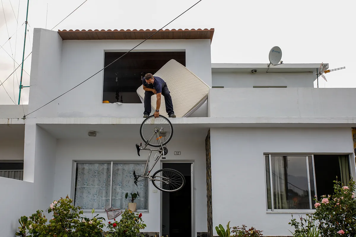 LA PALMA, SANTA CRUZ DE TENERIFE, SPAIN - SEPTEMBER 21: A man of the urban core of Todoque takes his bicycle out of the window during the eviction of their homes before the approach of lava from the volcano, on 21 September, 2021 in Los Llanos de Ariadne, in La Palma, on 21 September, 2021 in La Palma, Santa Cruz de Tenerife, Canary Islands, Spain. The approach of lava to the town of Todoque is imminent and the residents must leave their homes with their belongings in the next few hours. The river of lava from the 'Cumbre Vieja' volcano continues to advance towards the sea, although in the last few hours its pace has slowed down. The lava has covered a total of 103 hectares and has destroyed 156 buildings, according to the European Union's Copernicus satellite program. In addition, 5,500 people from villages near the volcano have been evacuated. (Photo By Kike Rincon/Europa Press via Getty Images)