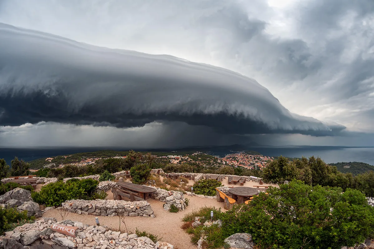 A stunning arcus cloud rolls across the Croatian coastline near Mali Losinj. Arcus clouds form at the gust front of thunderstorms, which is the leading edge of the rain-cooled air flowing out from the storm. The best examples usually occur when individual storm cells merge into larger clusters and lines of thunderstorms. The rain-cooled air from individual storms then combines into a much larger region of cold, dense air that can help to propel the area of storms forward as it spreads outwards. Arcus clouds that are as well-formed and extensive as the one photographed here are often accompanied by damaging wind gusts. Photo by Sandro Puncet