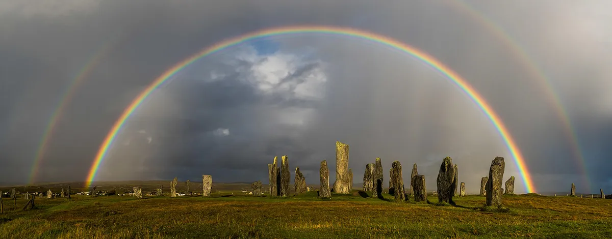 A spectacular double rainbow appears as sunshine follows a heavy shower at Calanais on the Isle of Lewis, Scotland. Rainbows form due to the refraction and reflection of sunlight as it passes through raindrops. The secondary, outer bow, in which the colour banding is in the opposite direction to the primary bow, occurs when light is twice reflected off the back of the raindrops. The secondary bow always lies nine degrees outside of the primary. Between the two bows, especially near the horizon, a phenomenon known as ‘Alexander’s dark band’ is apparent – a region in which the sky appears slightly darker than it does outside of the secondary bow and inside of the primary bow. This is because reflected light tends to brighten the sky outside of the secondary bow and inside of the primary bow. The phenomenon is named after Alexander of Aphrodisias who first described it in AD200. Photo by Neil Partridge