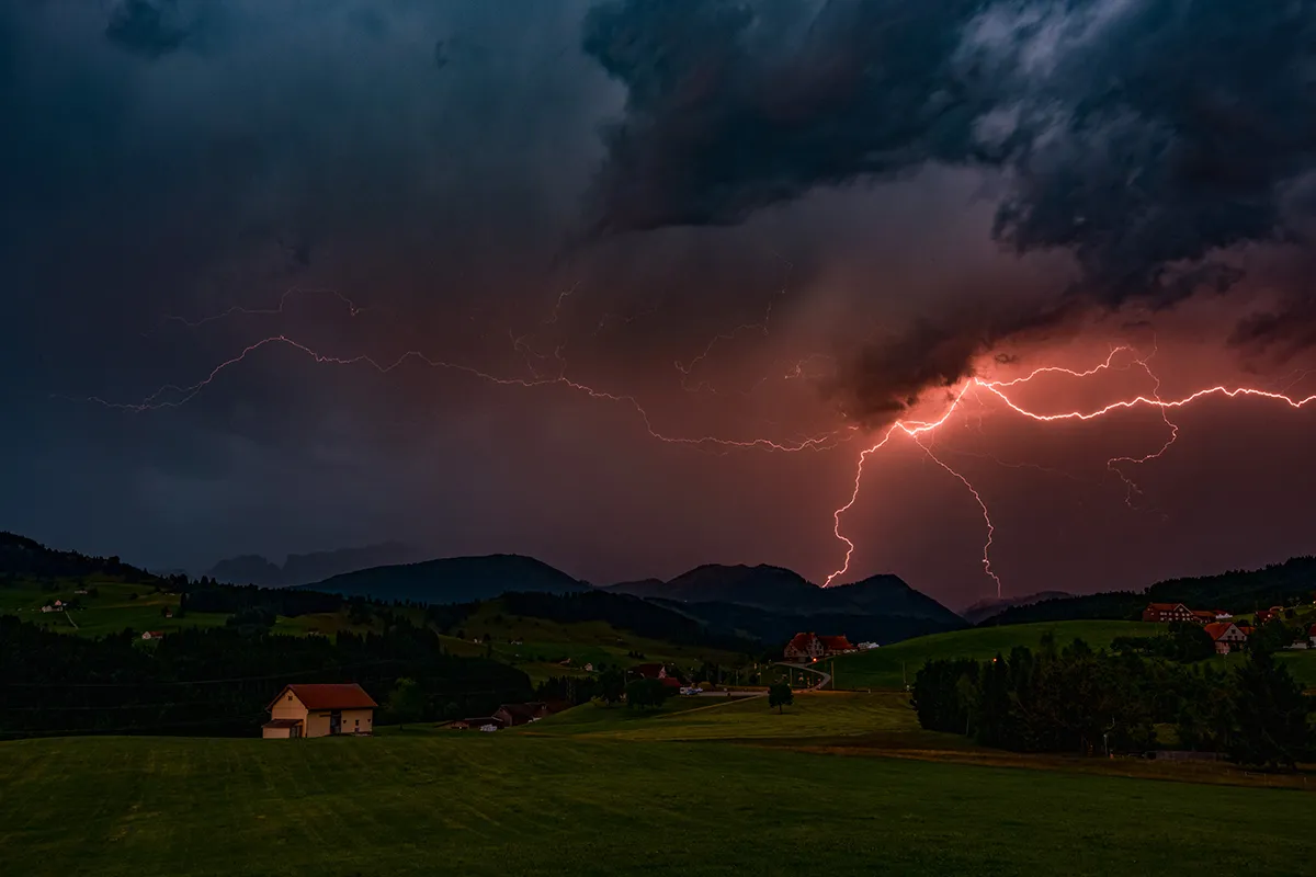 Pink-tinged lightning illuminates the mountains near Appenzellerland, Switzerland, during a powerful nocturnal thunderstorm. Robert says, ‘This photograph was taken in front of my house in Appenzellerland, Switzerland. As the storm developed I stood on my terrace to watch and photograph the spectacle. The flash frequency was quite high, which meant that I could work with relatively short exposure times. I particularly like this shot because of the ambient light in the clouds, and the beautiful pink coloration of the lightning which provides contrast with the green of the landscape’. Photo by Robert Juvet
