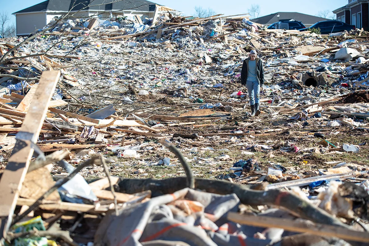 A man walks through the wrecked remains of houses