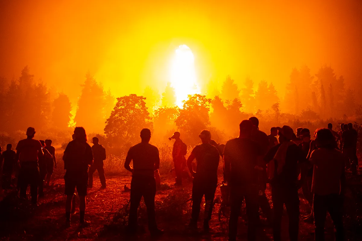 volunteers gather in an open field to fight greek wildfire