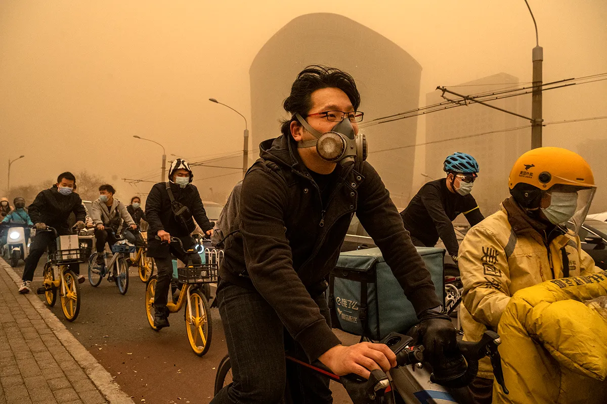 People wear protective masks as they commute sandstorm