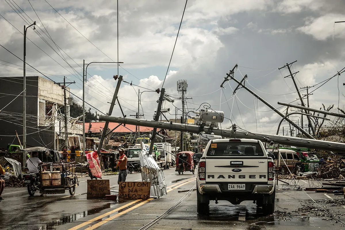 Fallen electric pylons block a road after typhoon