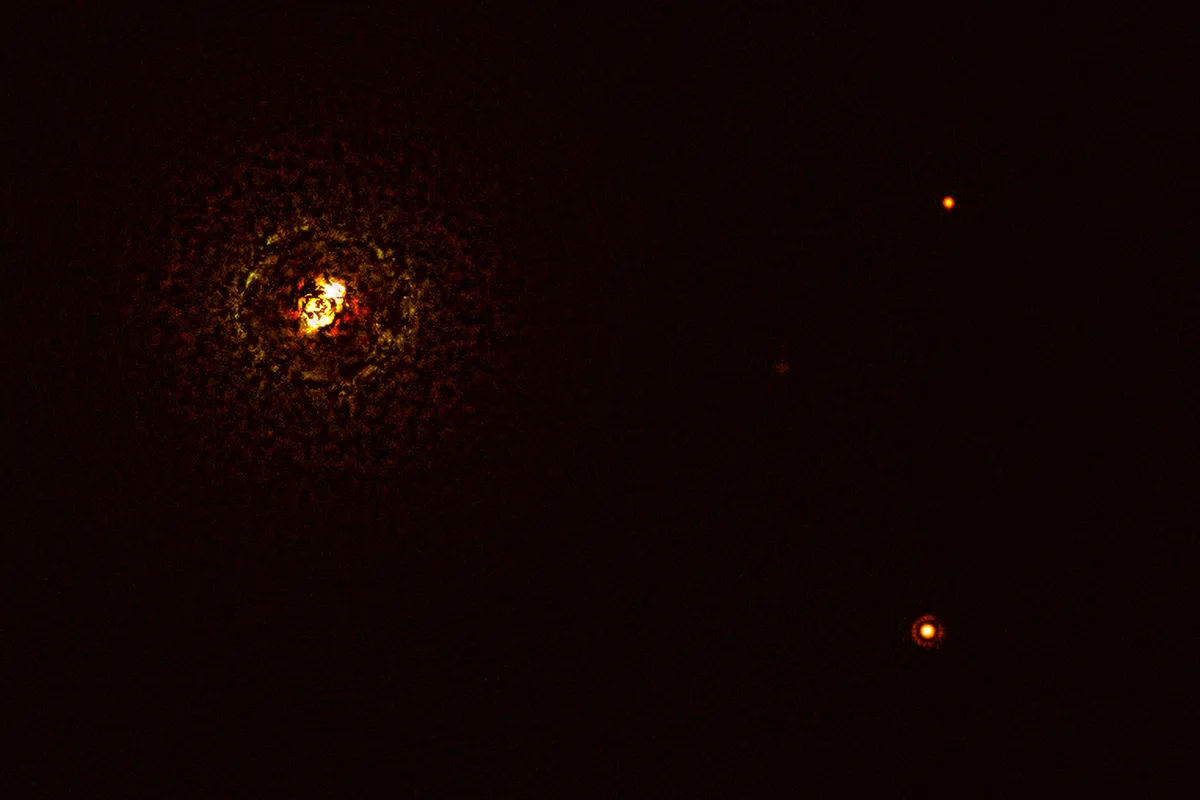 This image shows the most massive planet-hosting star pair to date, b Centauri, and its giant planet b Centauri b. This is the first time astronomers have directly observed a planet orbiting a star pair this massive and hot. The star pair, which has a total mass of at least six times that of the Sun, is the bright object in the top left corner of the image, the bright and dark rings around it being optical artefacts. The planet, visible as a bright dot in the lower right of the frame, is ten times as massive as Jupiter and orbits the pair at 100 times the distance Jupiter orbits the Sun. The other bright dot in the image (top right) is a background star. By taking different images at different times, astronomers were able to distinguish the planet from the background stars. The image was captured by the SPHERE instrument on ESO’s Very Large Telescope and using a coronagraph, which blocked the light from the massive star system and allowed astronomers to detect the faint planet.