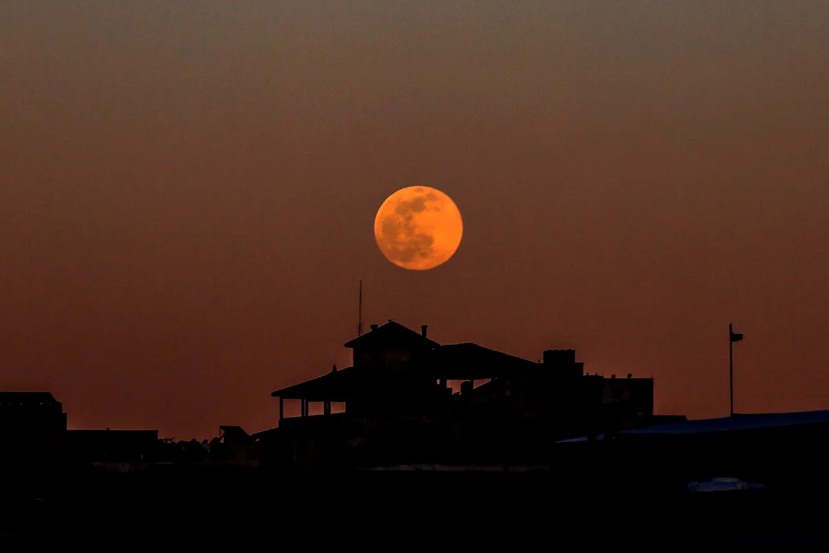 Full Moon rising above building