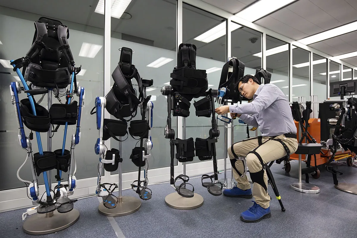 An engineer at Hyundai sits on a ’chairless exoskeleton’ while fixing one of the company’s wearable medical exoskeletons