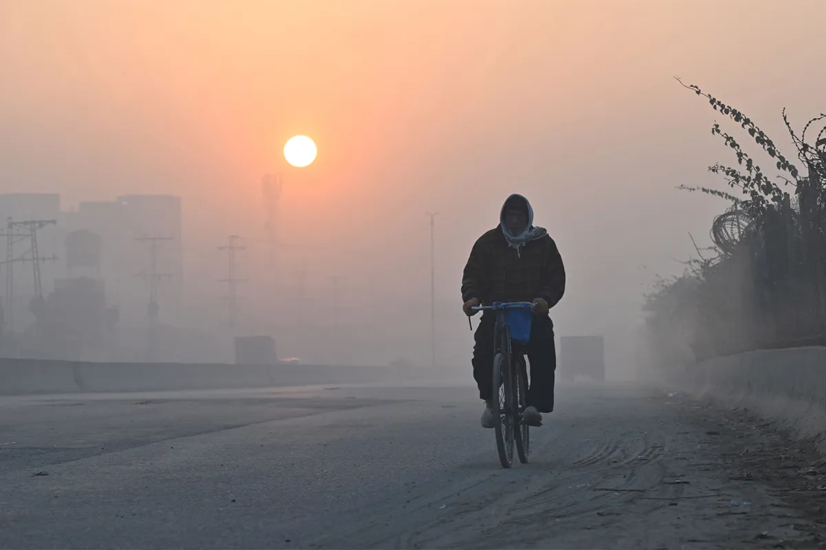man rides bike through smog