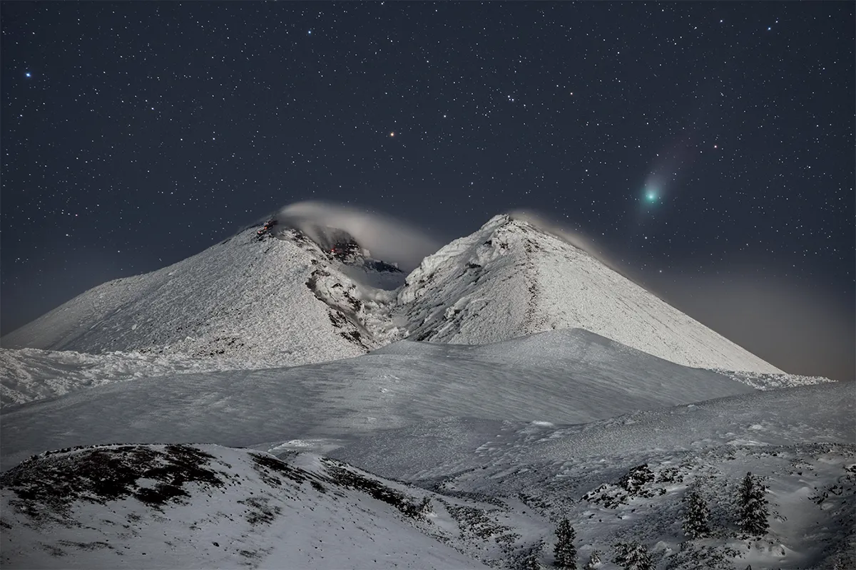 Comet above volcano at night