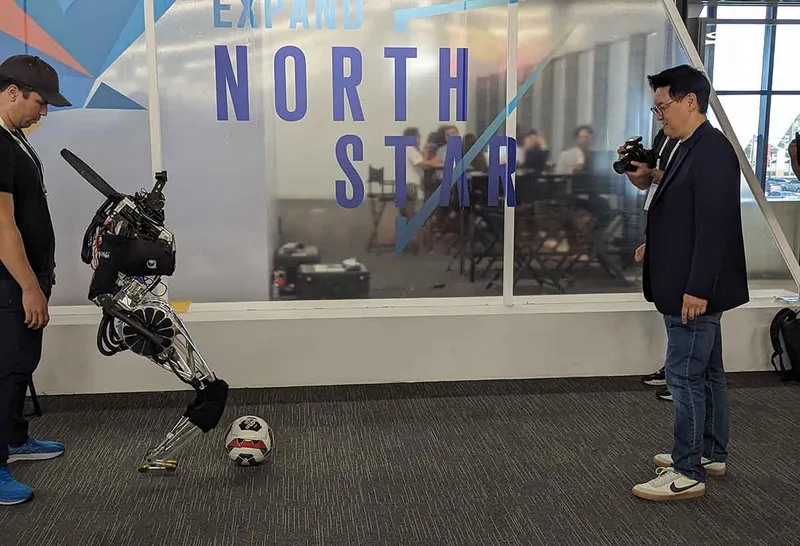 ARTEMIS robot kicking a football to its creator.
