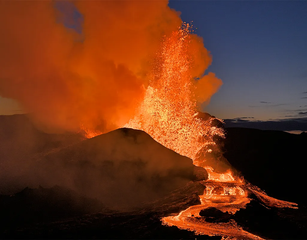 Huge volcano erupting orange lava