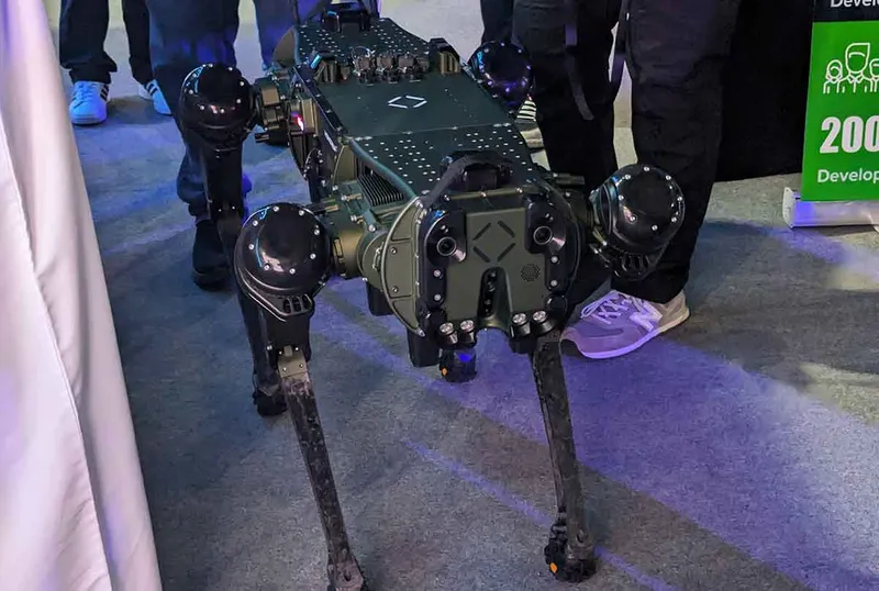 A large black robot dog with lots of moving parts, cameras and accessories.