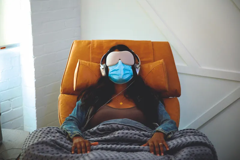 A photograph of a women in a chair undergoing guided VR therapy