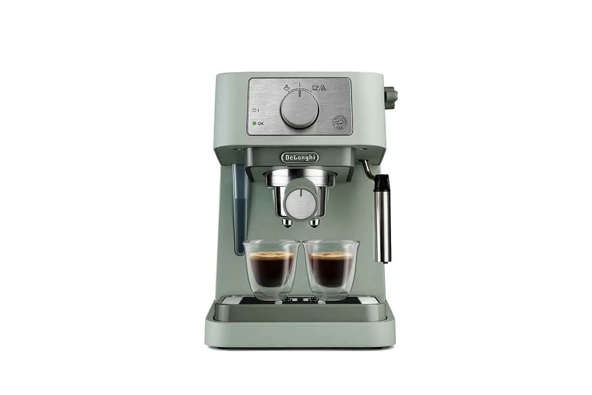 A sage green coffee machine sat in front of a white background with two poured coffees.