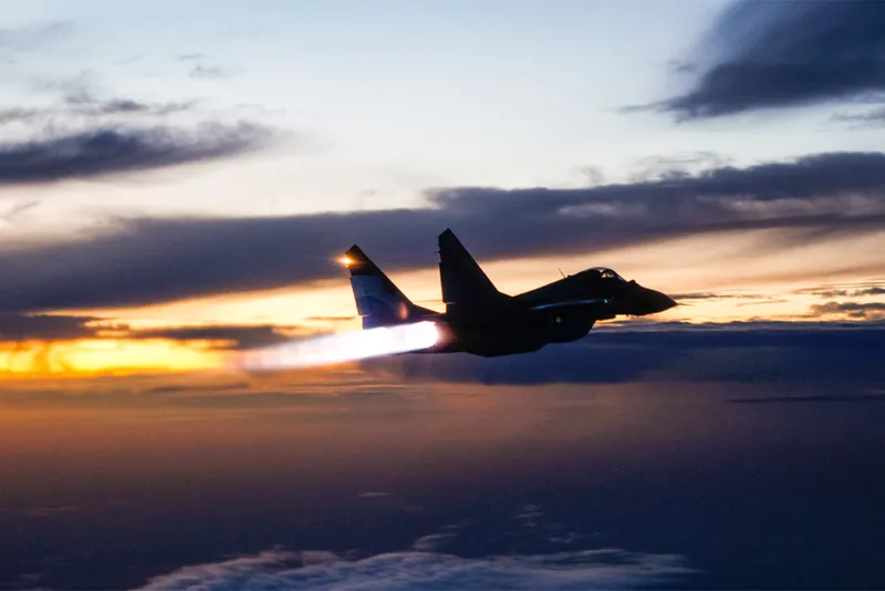 Fighter Jet plane silhouette against a sunset