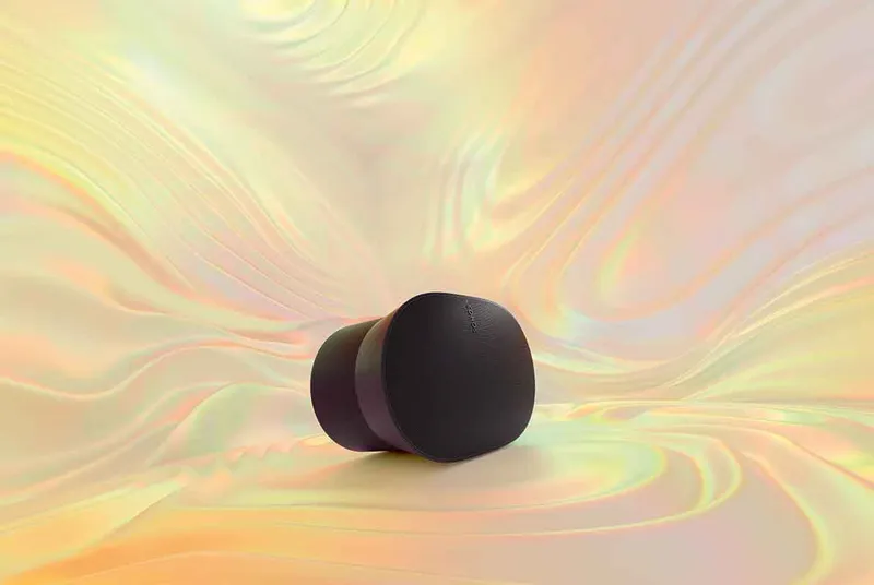 The Sonos Era 300 speaker in black sat on a background of rainbow colours