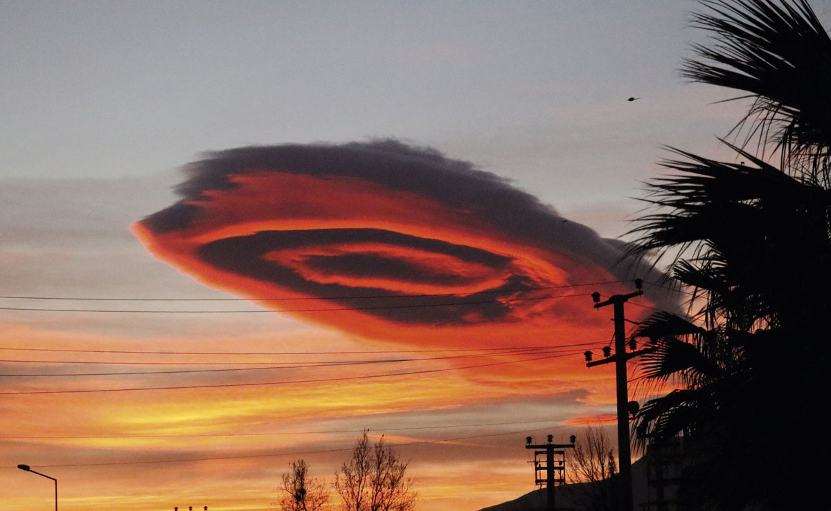 A giant pink cloud in the sky at sunset.