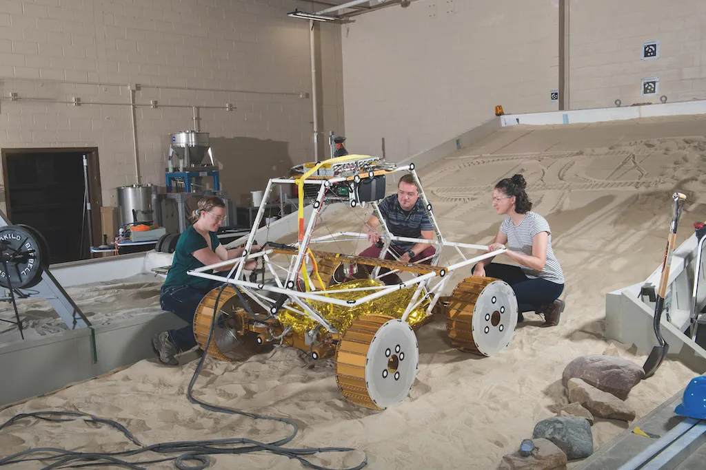 A photograph of some researchers working on the Virtual Intelligent Planetary Exploration Rover (VIPER)