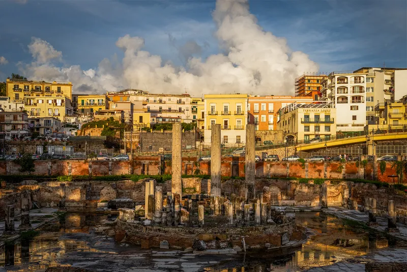 Ancient town with columns and clouds in background