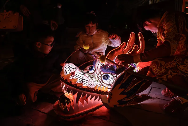 Children look at glowing dragon puppet