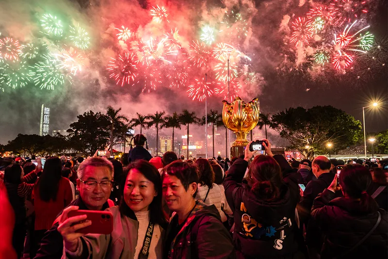 People taking selfie with fireworks behind