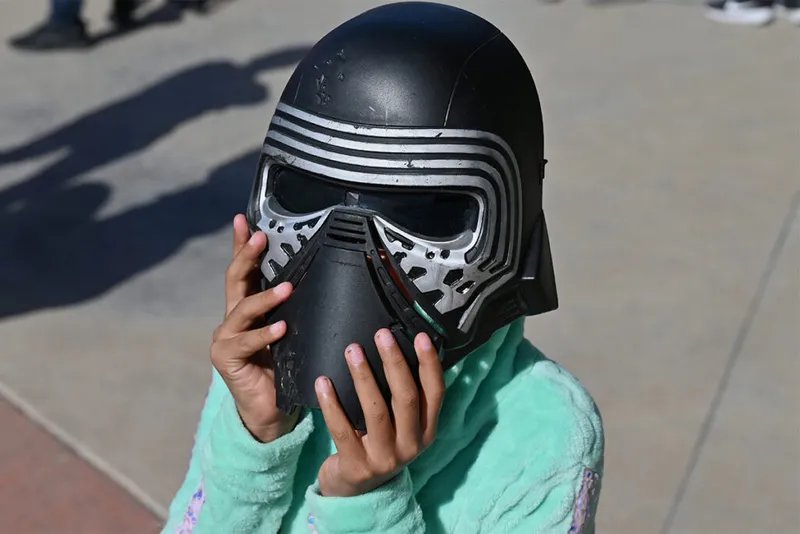 Child wears black plastic sci-fi mask