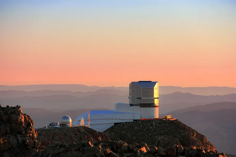 telescope on side of mountain at sunset.