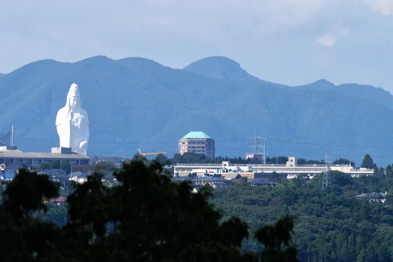Skyline with hills and huge white statue.