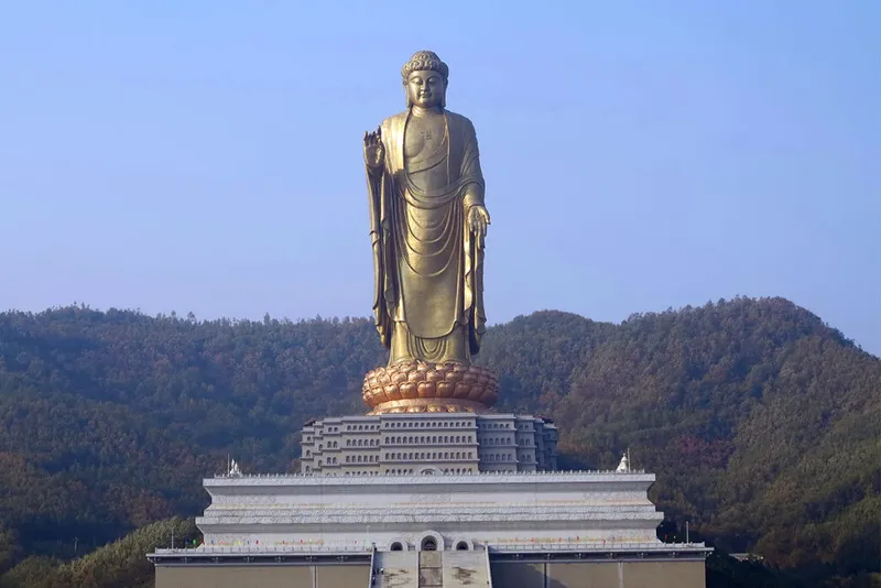 Huge golden statue above temple.