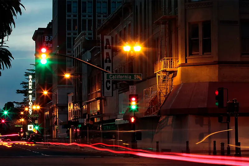 City street corner with blurred lights at night.