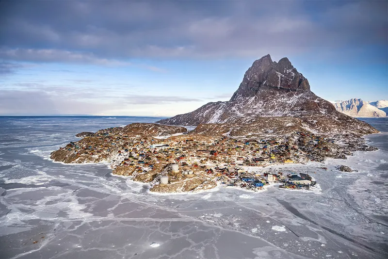 An aerial view of small island with ice and houses