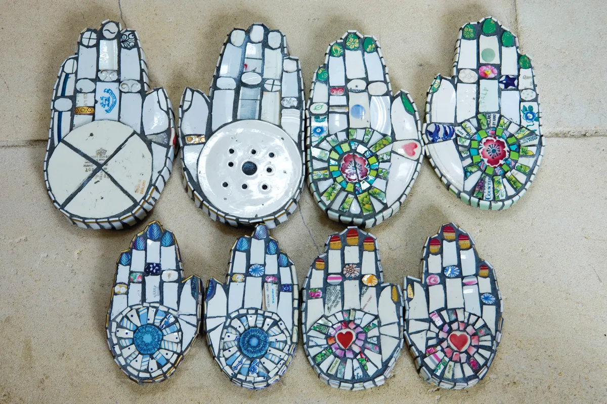 Cleo Mussi has used broken pieces of plates to create hands with different patterns on the palms