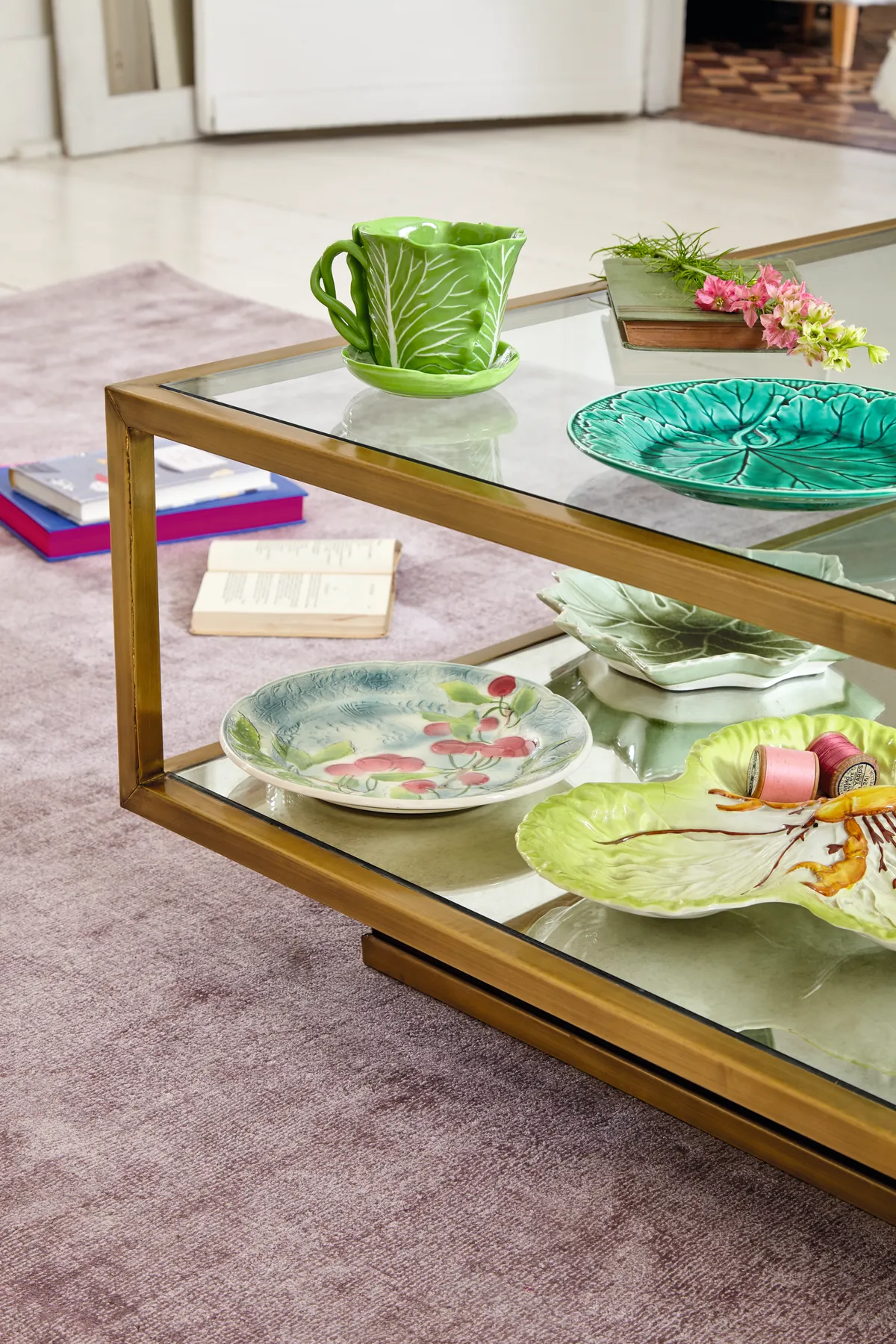 Place unusual plates on the bottom shelf of a glass coffee table for a display that’s easy to update and experiment with mixing old and new ceramics