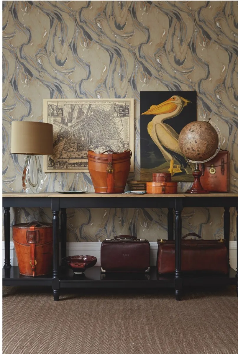 On console: from left: ‘Astrid’ table lamp with shade in antique gold silk, £774.20, Heathfield & Co. John Derian ‘L’Ara Parrot’ tray, £110, The Conran Shop. Leather double top hat bucket, c1905, £1,950, Bentleys. Old books, from £20, Pimpernel & Partners. Paris 1818 reproduction map, £19.95, Liberty. Large leather collar box by Perry & Perry, c1920, £195; small leather collar box, £145; leather drinks case, £1,100, all Bentleys. Large globe, £199.95, LibertyBottom shelf, from left: Triple hat bucket, c1900, £1,950, Bentleys. ‘Tulpe’ medium aubergine bowl, £275, The Conran Shop. Burgundy Gladstone bag with filing compartments, £790; hide Gladstone bag, £320, both Henry Gregory. Other items: ‘Upton’ console in black with weathered oak top, £965, Oka On wall: American White Pelican birch ply print from Natural History Museum collection, 80 x 120cm, £305; View of Amsterdam birch ply print from National Maritime Museum collection, 80 x65cm, £225, both SurfaceView. ‘Albatre’ wallpaper in ‘Gris Camel’, 72910494, £56.80 per roll, Casamance. ‘Herringbone Sisal’ in mocha, E404, £56 per sq m, Crucial Trading