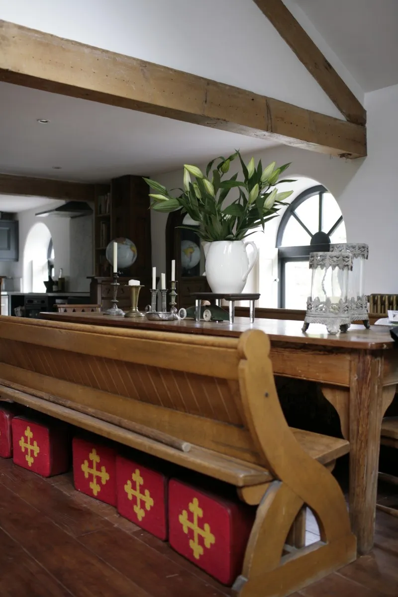 Reclaimed vintage church pews are used as dining room benches in Drew Pritchard's home.