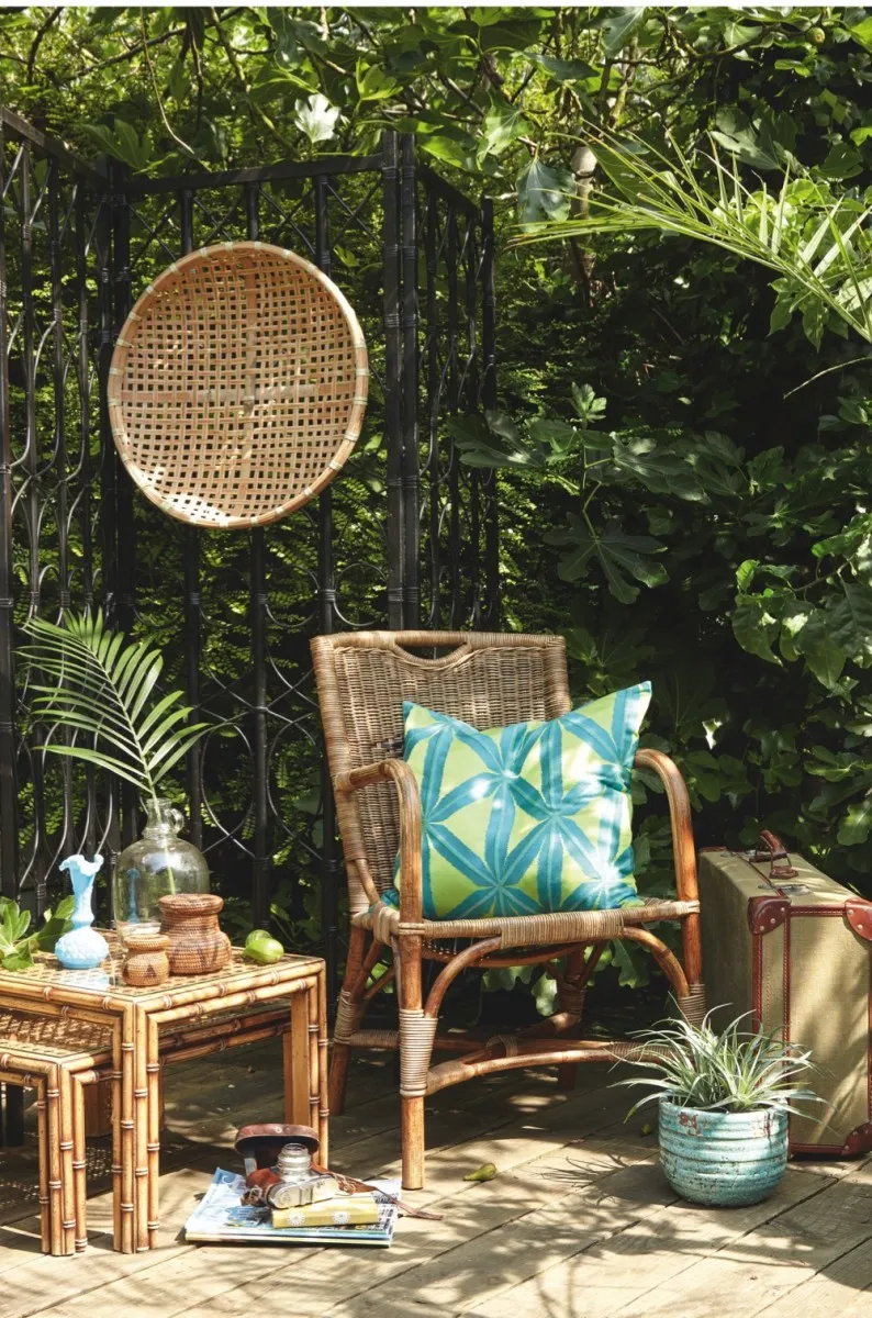 An outdoor scene featuring a woven rattan chair and side table