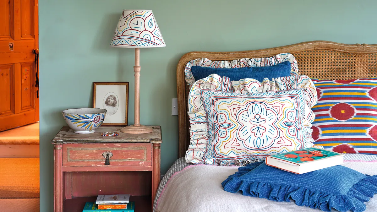 plenty of pillows and a bedside table with a lamp ensure you have every comfort to hand. Printed lampshade and cushions, from £70, Montes & Clark.